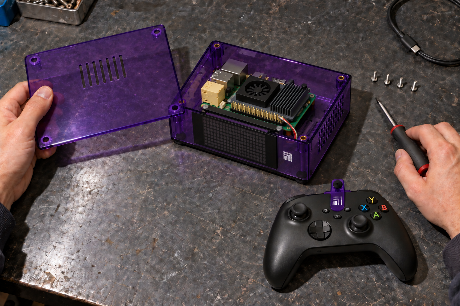 Hands lift the purple Threebox lid and hold a screwdriver over a scratched workbench. The unplugged box has a dark LED panel, with the controller and mic beside it.